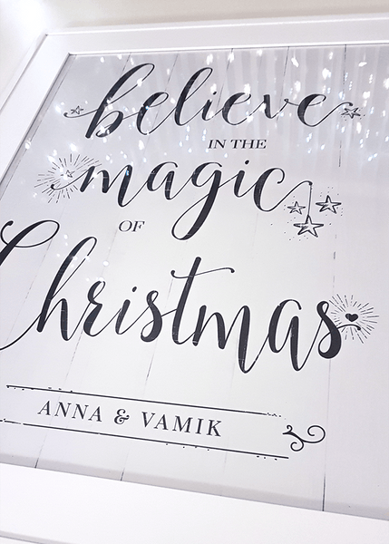 Close up of framed Believe Personalized Print with Christmas lights reflecting in the glass