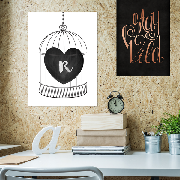 Bird cage with a heart and initial inside. Black and white print in a modern teenager's room