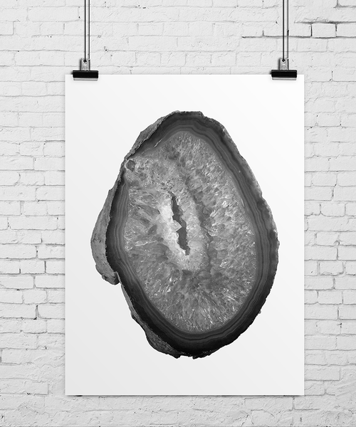 Agat crystal image print in soft, black and white tones hanging on a white brick wall