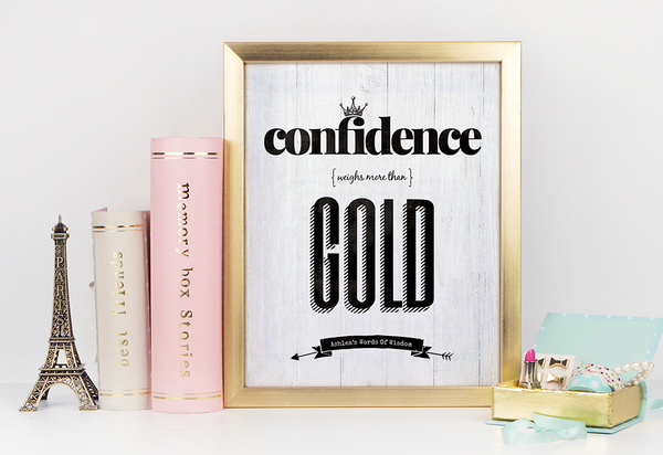 Desk with gold accents and a framed Confidence Weighs More Than Gold print