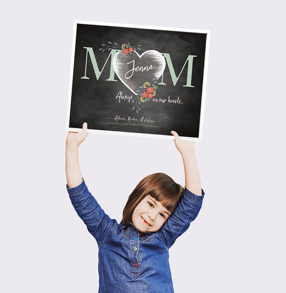 Little girl holding up Mom Heart personalized print for Mother's Day