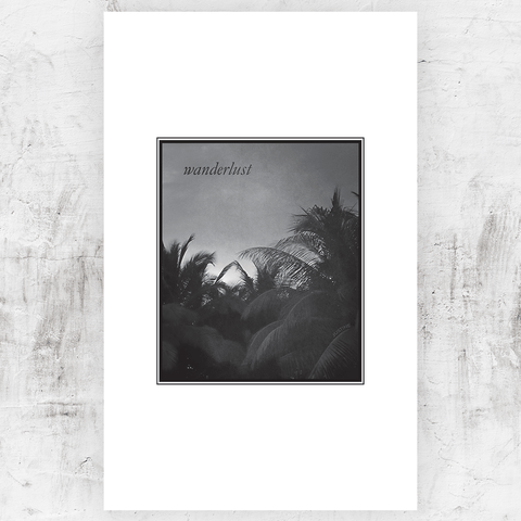 Black and white print of tops of palm trees with a word "Wanderlust" in the sky. Personalize this print with your first name in the trees!
